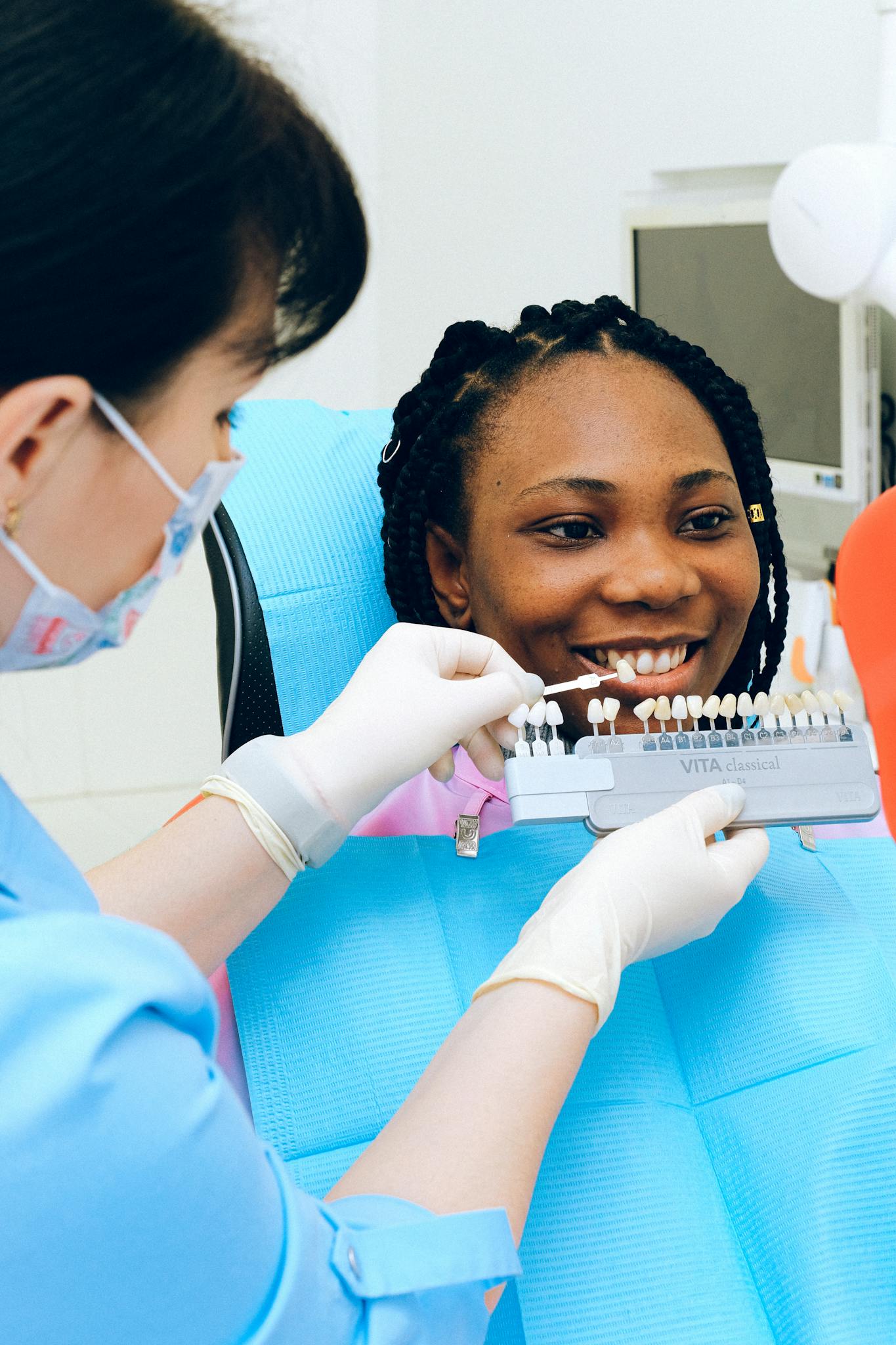 Woman being presented with veneer shades for her teeth. Ivy Lane Dentistry offers veneers as a service. Cosmetic dentists san antonio. 