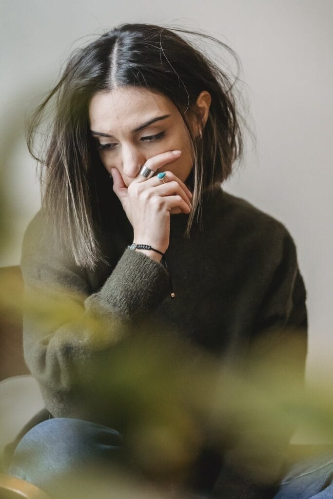 Lady crying with hand on mouth in room. Ivy Lane Dentistry offers emergency dentistry services in San Antonio, TX.